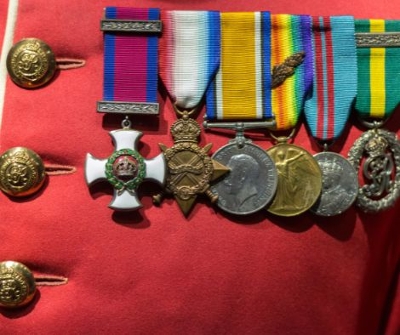 6 military medals on red coat.