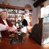 Volunteers on the Victorian Street measuring sweets in traditional sweet shop.