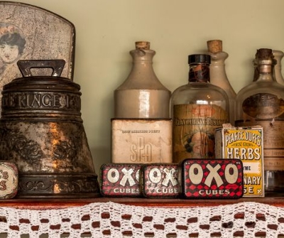 Selection of old red tinned items that are slightly rusting and empty jars.
