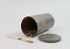 Metal tub on its side with the lid off containing friction matches