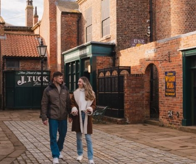 Couple walking through Victorian street at sunset