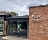 Front of the park cafe showing the sliding electric doors and the park cafe logo on the brick wall.