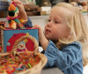 Young child with playing with an old jack-in-the-box toy.