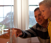 Child and an adult looking through the glass and pointing at old historic items.