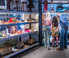 Family of 3 people looking through glass at old objects.