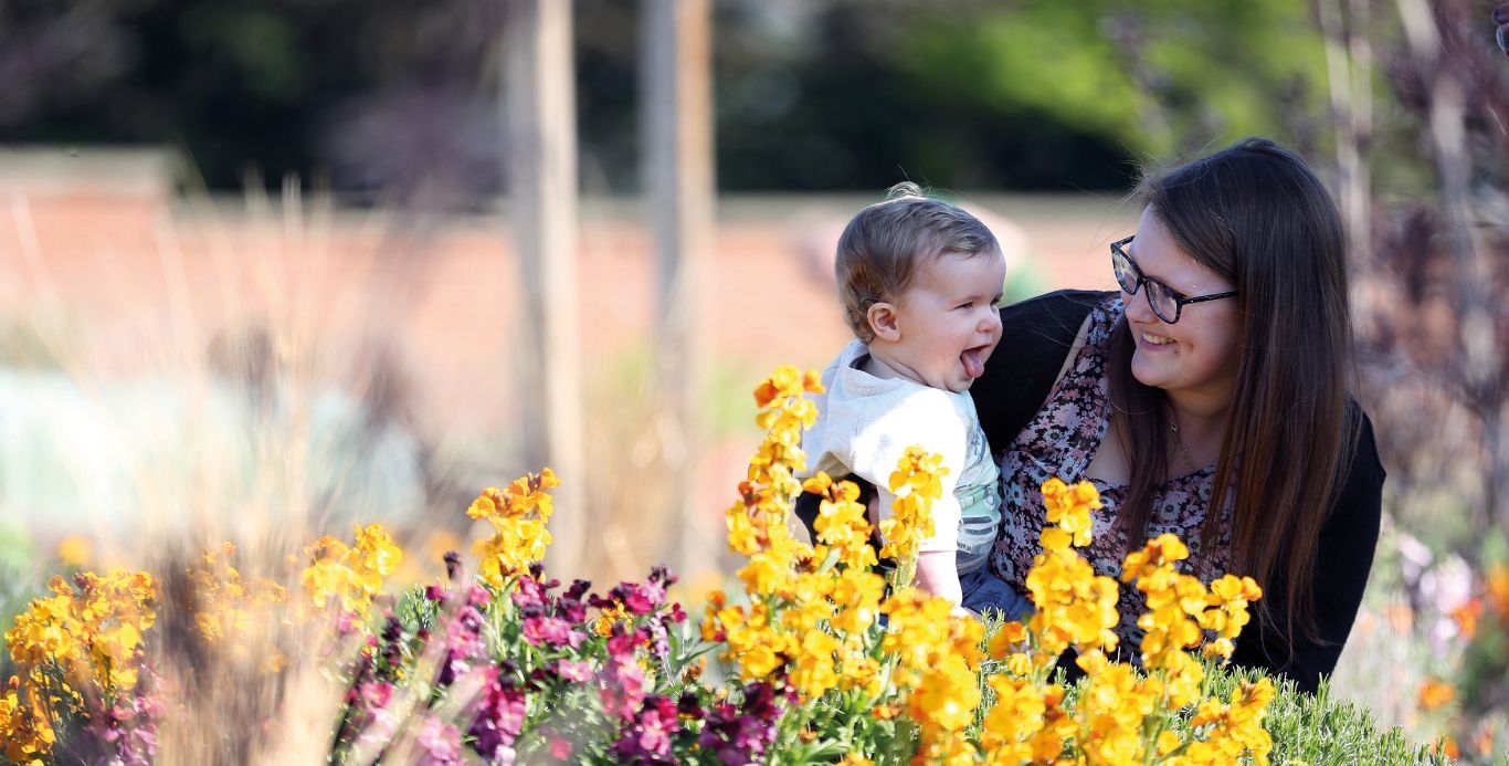 An image of a mother and baby exploring the flower beds in the Walled Garden
