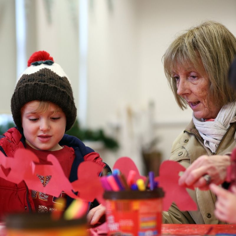 Child And Grandparent Making Christmas Craft