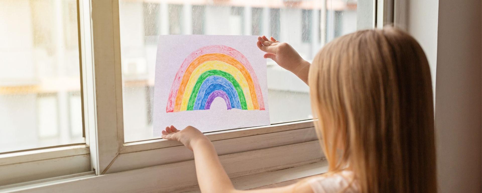 Girl Putting Her Rainbow Picture In The Window.jpeg